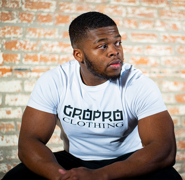 Male model wearing the White GROPRO Clothing design t-shirt with black text across the center chest area. 