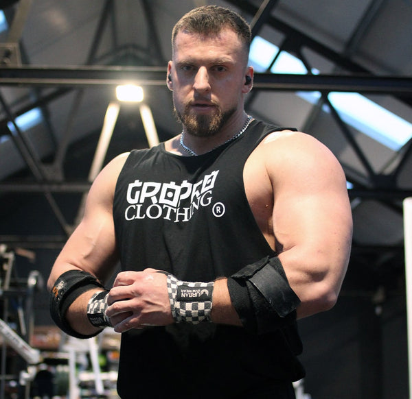 MALE MODEL FOR WWW.GROPRO.CO.UK WEARING BLACK VEST WITH GROPROCLOTHING ACROSS THE FRONT CHEST AREA.